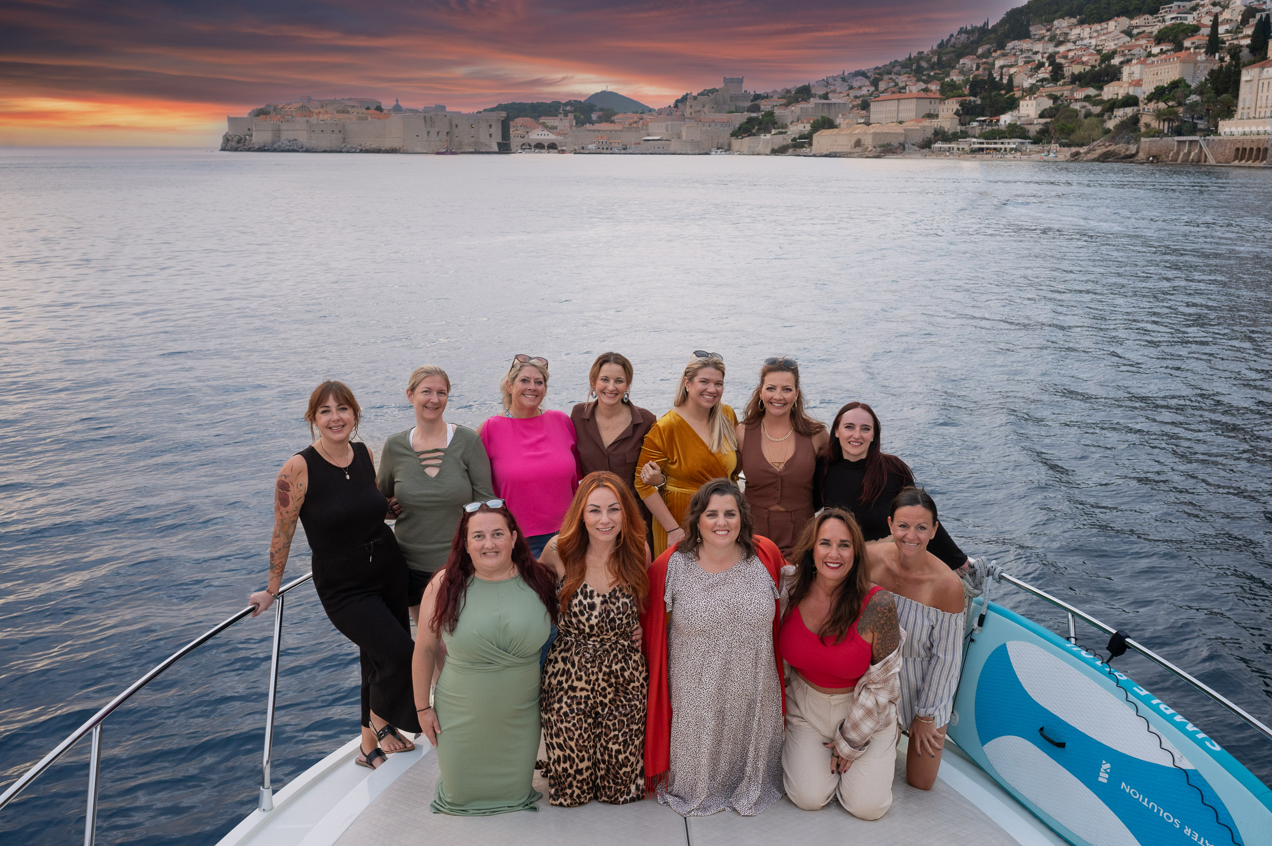 a group of women on a boat off the coast of Dubrovnik, Croatia at sunset as a part of their women's retreat