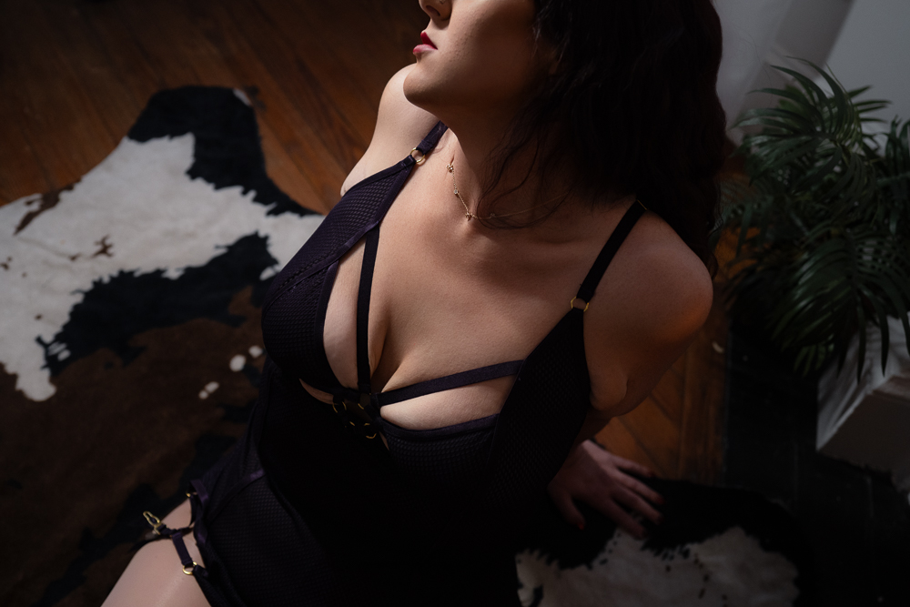 close up detail shot of a woman in a purple chemise sitting on the floor during a boudoir shoot in wilmington, nc